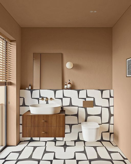 Modern bathroom with contrasting porcelain and ceramic tiles in geometric patterns, featuring wooden vanity.