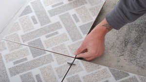 Person installing geometric ceramic vs porcelain floor tiles.