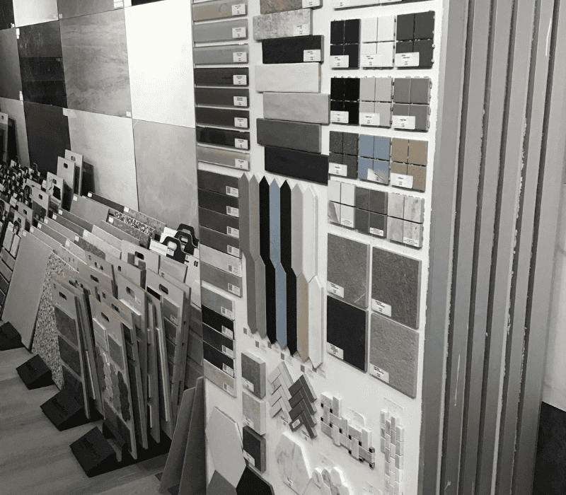 Display of various tile samples in a showroom, showcasing different colors, sizes, and textures for tile installation.