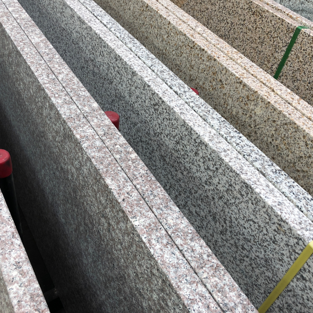 Large slabs of granite and quartz in various colors, arranged upright for selection.