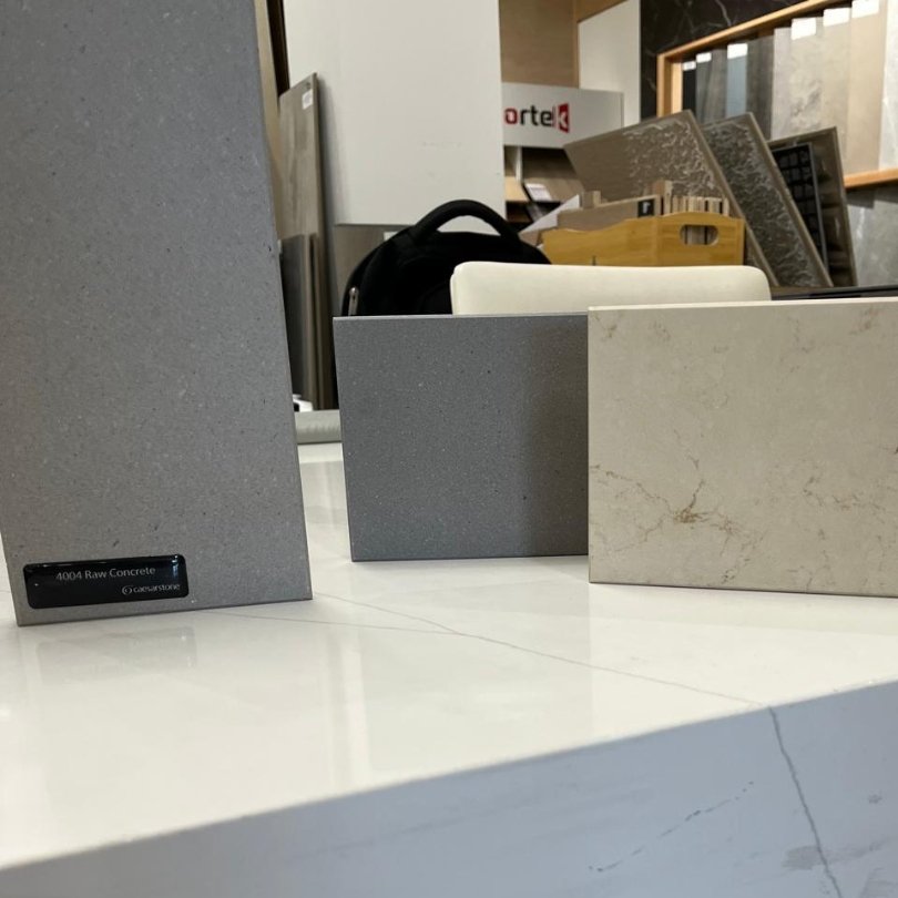 Caesarstone Quartz surfaces samples in different colors and textures displayed in a showroom.